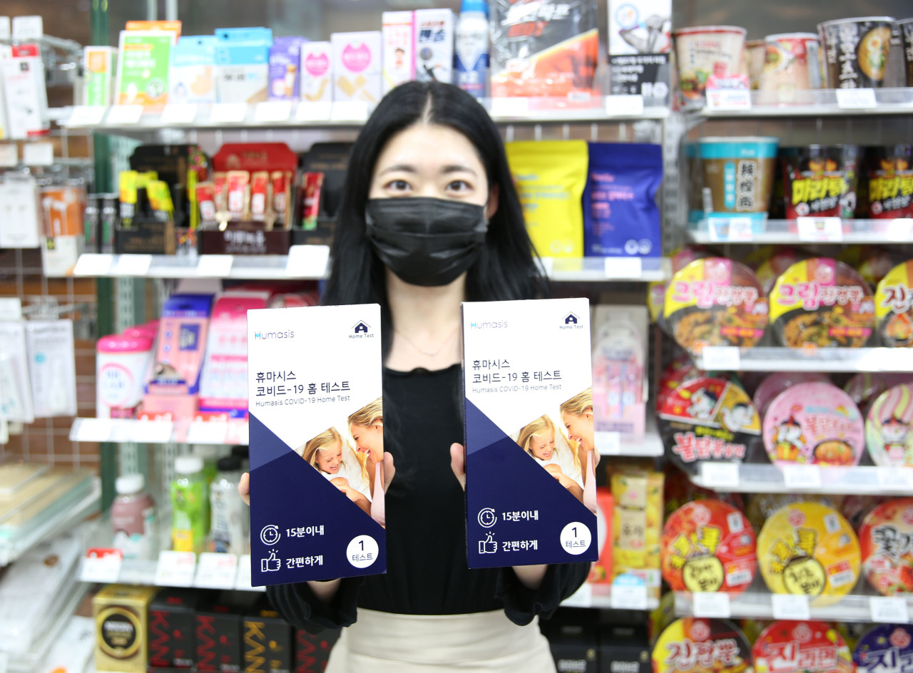 A model holds COVID-19 test kits developed by Humasis at a branch of convenience store chain GS25. (GS25)