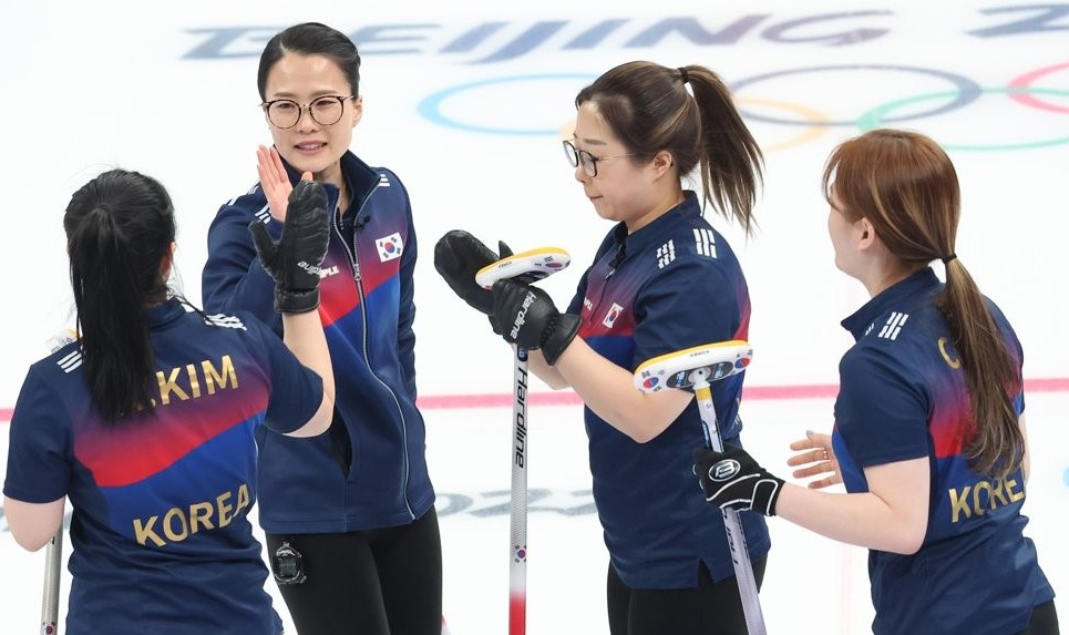 South Korean curlers Kim Kyeong-ae, Kim Eun-jung, Kim Seon-yeong and Kim Cho-hi (L to R) celebrate a point against Sweden during a women's curling round-robin game at the Beijing Winter Olympics at the National Aquatics Centre in Beijing on Feb. 17, 2022 (Yonhap)