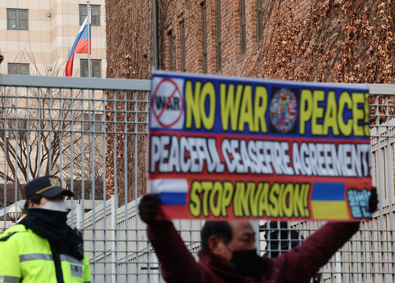 Hong Jeong-sik of civic group Hwal-bin-dan holds a sign that says “No war, peace. Peaceful ceasefire agreement! Stop Invasion,” during his one-man protest in front of the Russian Embassy in Seoul on Thursday. (Yonhap)