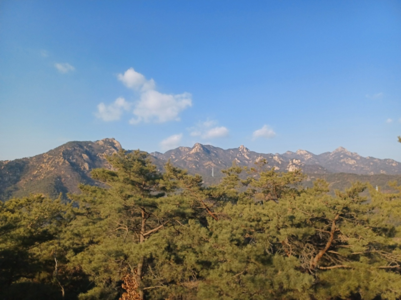 From left: Four peaks -- Jokduribong, Hyangnobong, Bibong and Munsubong -- of Bukhansan can be seen after climbing 200 steps at the Rose Garden. (Lee Si-jin/The Korea Herald)