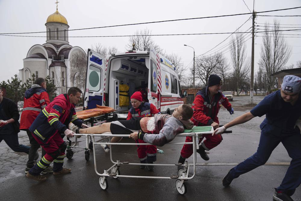 Ambulance paramedics move an injured man on a stretcher, wounded by shelling in a residential area, at the maternity hospital converted into a medical ward and used as a bomb shelter in Mariupol, Ukraine, on Tuesday. Russian strikes on the key southern port city of Mariupol seriously wounded several people. (AP Photo/Evgeniy Maloletka)