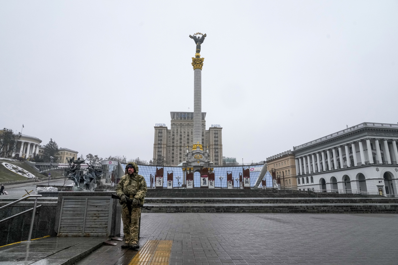 An armed man stands at the empty Independent Square (Maidan) in the center of Kyiv, Ukraine, Wednesday, March 2, 2022.