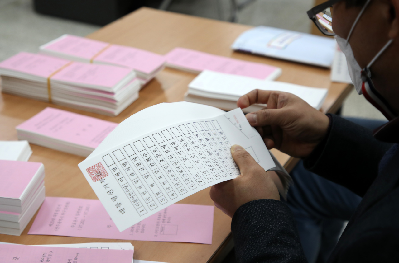 A polling officer inspects ballot papers at a district office in Gwangju, Monday. (Yonhap)