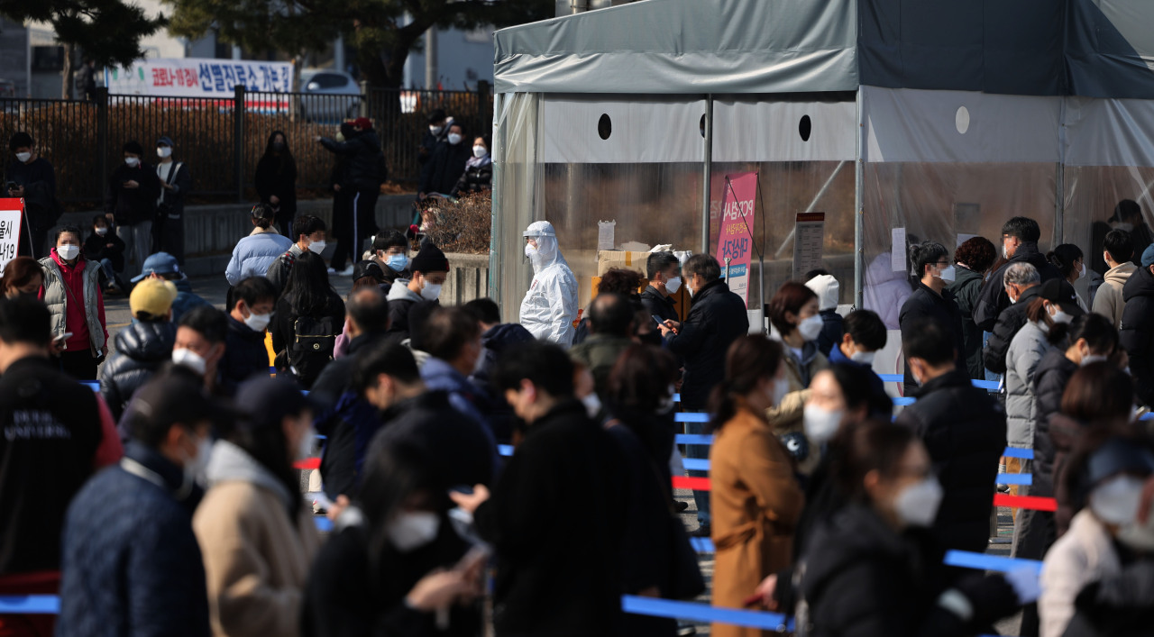 People wait in line for a COVID-19 test at a testing site in Seoul, Wednesday. (Yonhap)