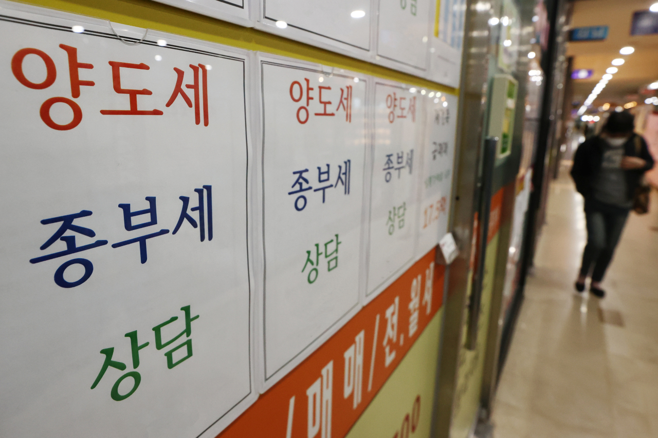 Postings at a real estate agency in Seoul on Sunday promotes its consulting service on the capital gains tax and comprehensive real estate tax. (Yonhap)