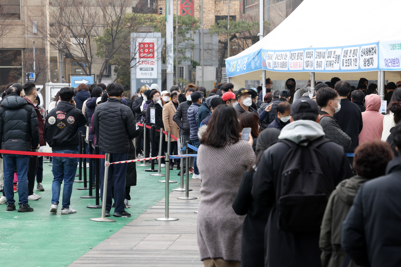 People line up for COVID-19 tests at a testing facility located in central Seoul last Tuesday. (Yonhap)
