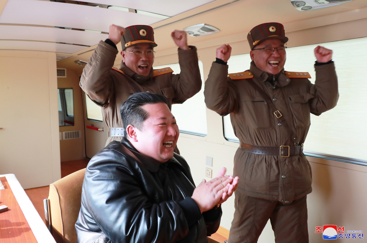 North Korean leader Kim Jong-un (front) celebrates after a Hwasong-17 intercontinental ballistic missile (ICBM) was launched from Pyongyang International Airport on Thursday, in this photo released by North Korea's official Korean Central News Agency. (Yonhap)