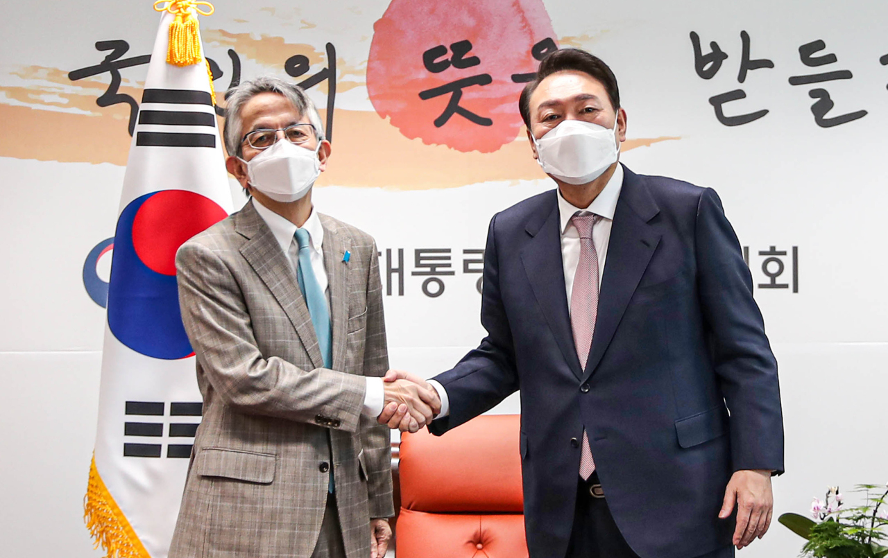 President-elect Yoon Suk-yeol (right) shakes hands with Japanese Ambassador to Seoul Koichi Aiboshi at Yoon's office in Seoul on Monday. (Yonhap)
