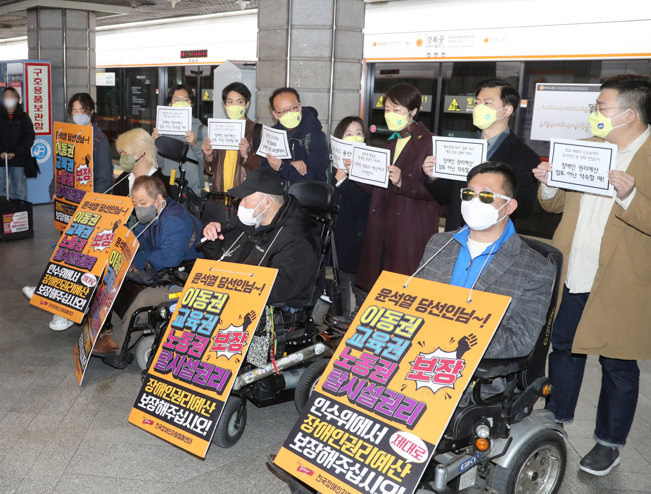Members of the with the Solidarity Against Disability Discrimination hold a press conference at the platform of Gyeongbokgung Station in Seoul on Tuesday. (Yonhap)