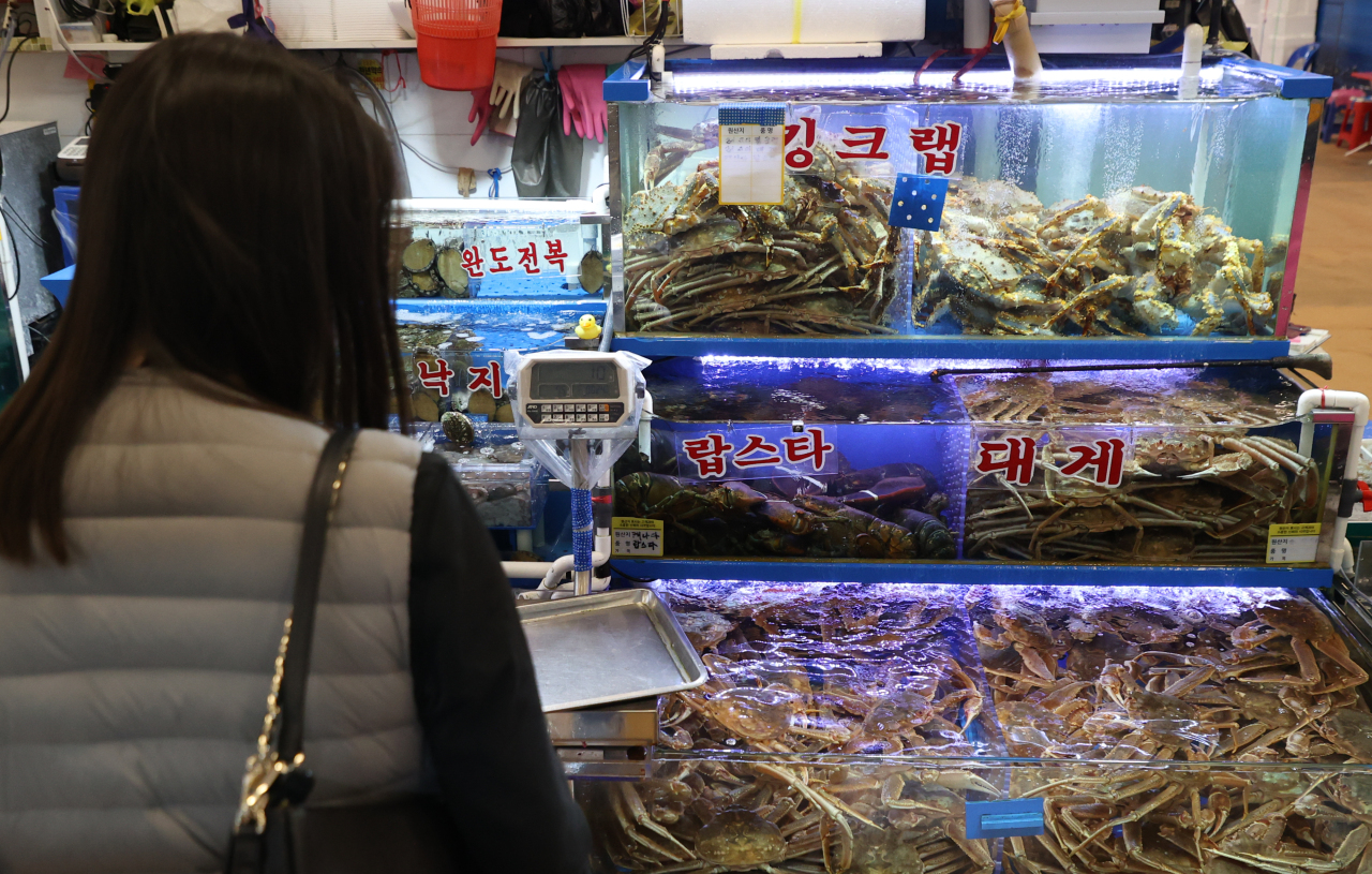 A customer shops for snow crabs at the Noryangjin Fisheries Wholesale Market in Dongjak-gu, Seoul, April 6. (Yonhap)