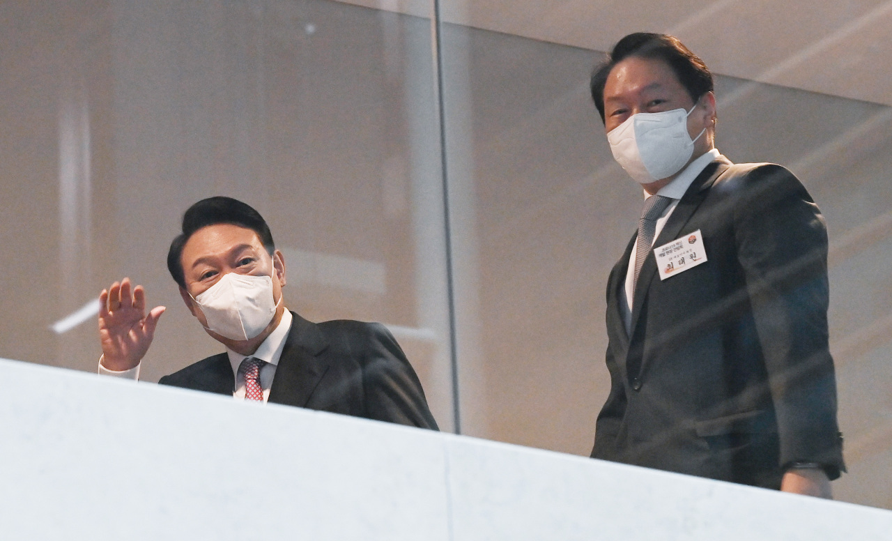 President-elect Yoon Suk-yeol (left), accompanied by SK Group Chairman Chey Tae-won (right), waves to SK Bioscience staff as he visits the drugmaker‘s headquarters in Seongnam, Gyeonggi Province, Monday. (Yonhap)