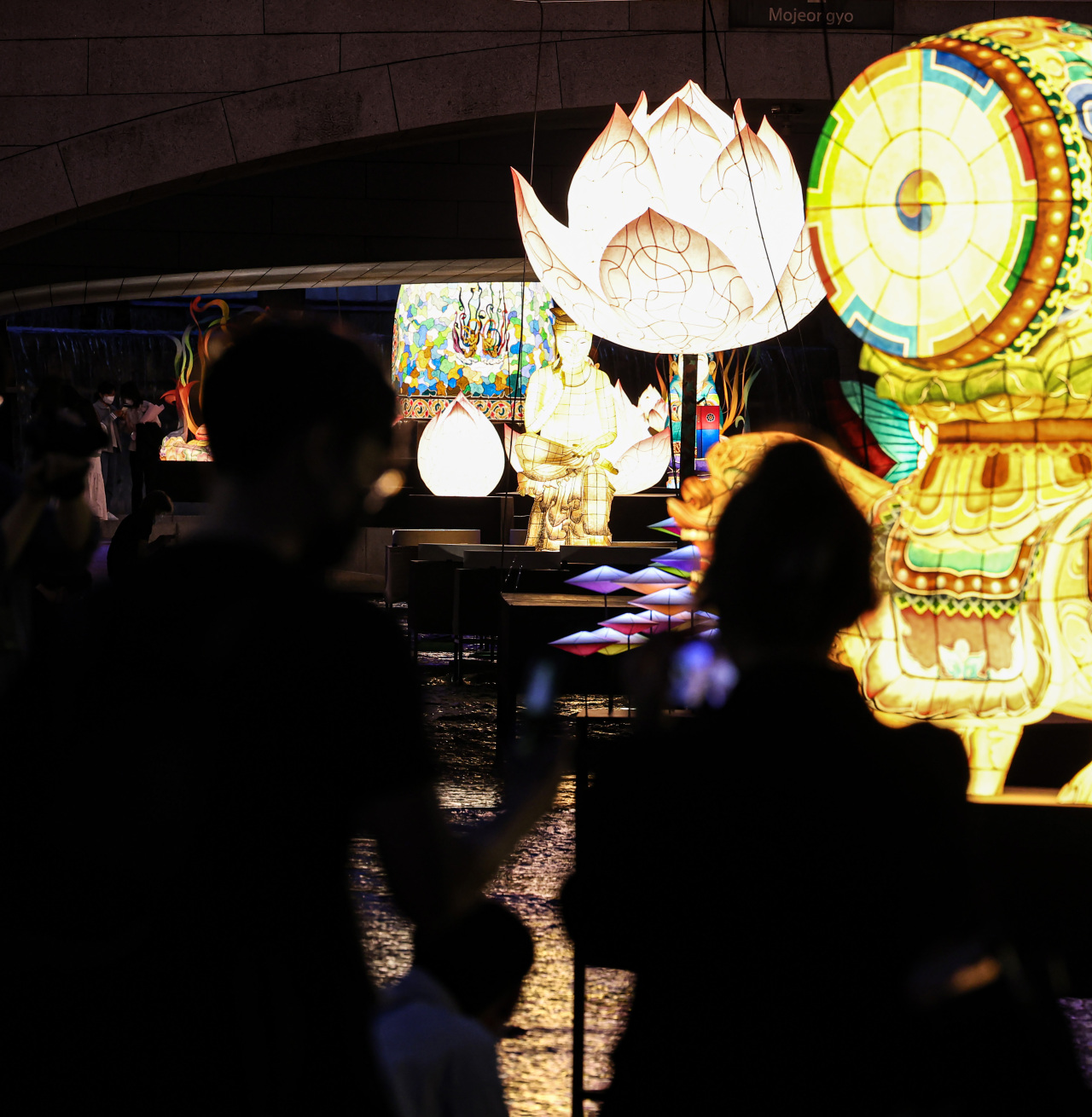 A visitor at Cheonggye Stream takes a photo of the traditional lanterns on display on Tuesday. (Yonhap)