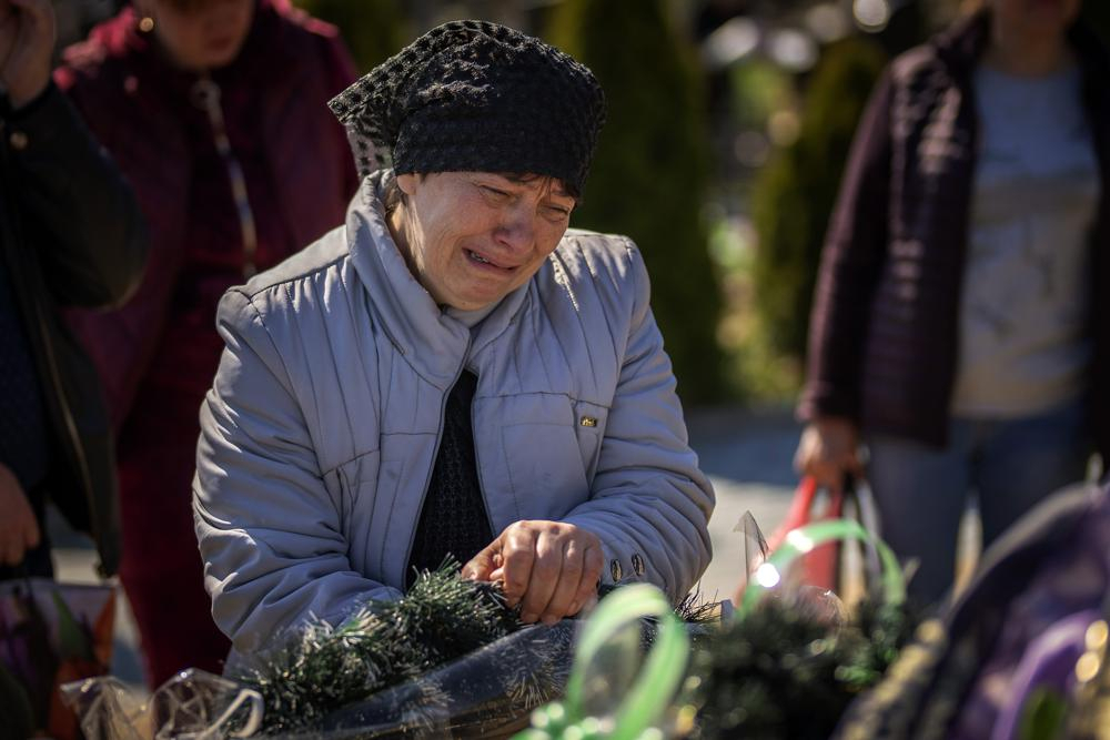 The mother of Oleksandr Mozheiko, 31, an Irpin Territorial Defense soldier killed by Russian army, cries at his grave at the cemetery of Irpin, on the outskirts of Kyiv, on Sunday. (AP)