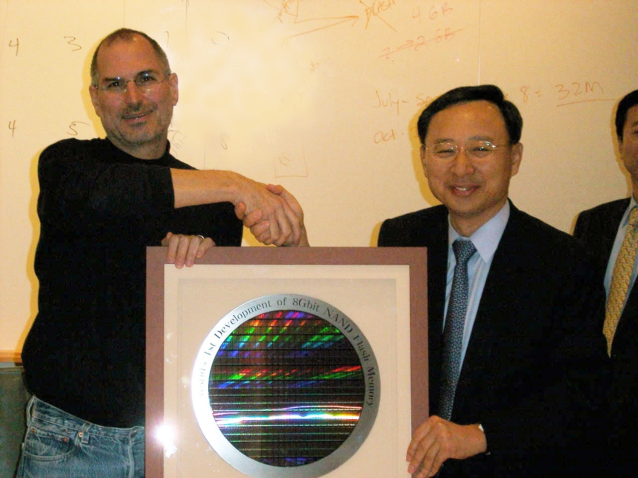 This photo shows Hwang Chang-gyu, author of “Encounters with Great Minds,” giving Apple co-founder Steve Jobs the 60-nanometer 8-gigabit NAND flash wafer after their meeting in December 2004 in Cupertino, California. (Sigongsa)
