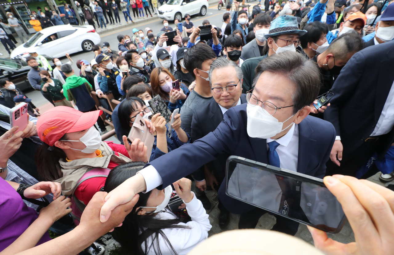 Former Gyeonggi Province Gov. Lee Jae-myung greets his supporters Sunday upon announcing his bid to join the parliamentary by-elections scheduled for June 1. (Joint Press Corps)