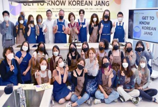 Foreigners pose during a cooking class for Korean food in Seoul’s Bukchon on Monday. (Agriculture Ministry)