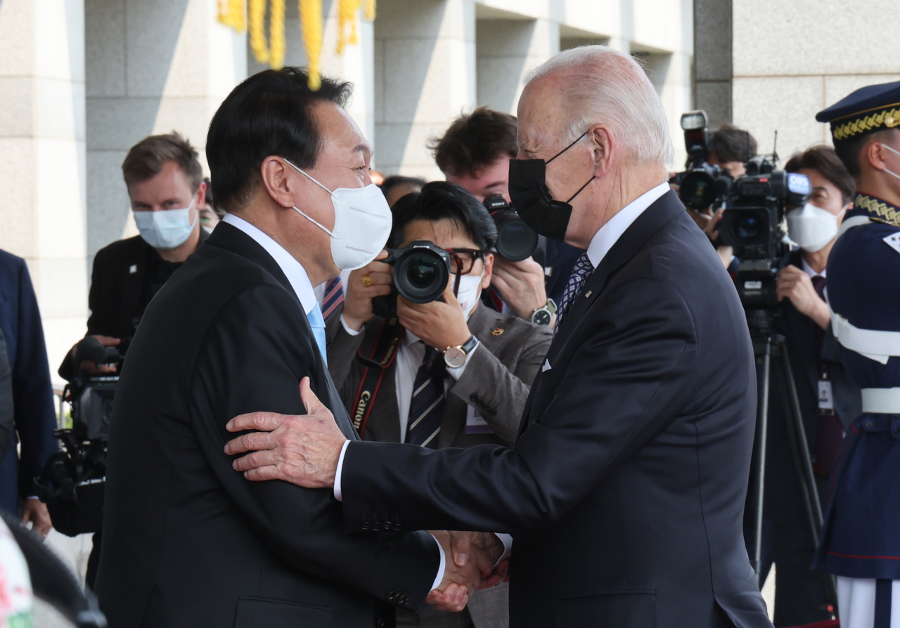 President Yoon Suk-yeol (left) greets US President Joe Biden at the presidential office in Yongsan-gu, Seoul, Saturday. (Yonhap)
