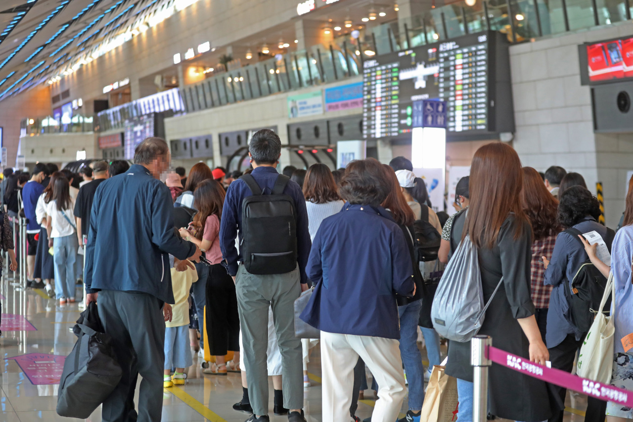 Passengers wait in lines at Incheon International Airport, the country’s main international gateway in Incheon, Friday. (Yonhap)