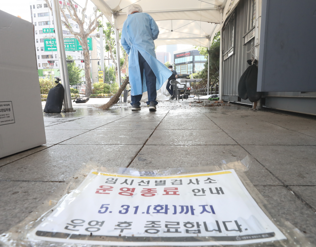 A medical worker sweeps the floor at a COVID-19 testing station in Seoul's central district of Jongno on Tuesday, a day before its closure as South Korea is set to remove most of the makeshift booths amid a decline in infections. (Yonhap)