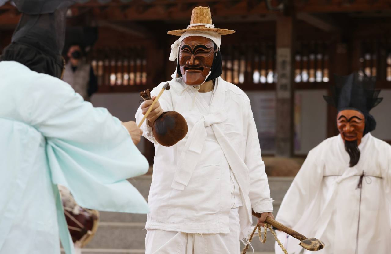 The butcher (center) tries to sell bull’s testicles to the scholar (left) and the nobleman during a Hahoe Byeolsingut Talnori mask dance in the Hahoe village of Andong, North Gyeongsang Province. Photo © Hyungwon Kang