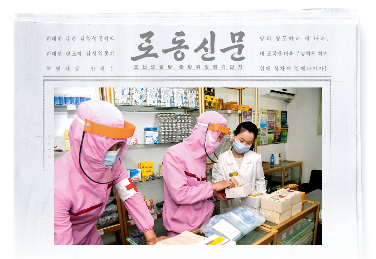 North Korean people’s Army military doctors, wearing what appear to be pink-hooded jackets and face shields, are seen at a pharmacy in an image released by the state’s Korean Central News Agency on Tuesday. (Photo: Yonhap. Graphic: The Korea Herald)