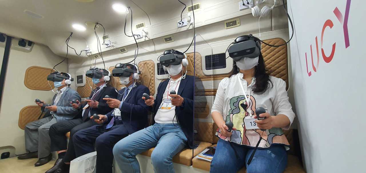 People play immersive games with virtual reality sensory headsets inside Lucy Bus. (Looxid Labs)