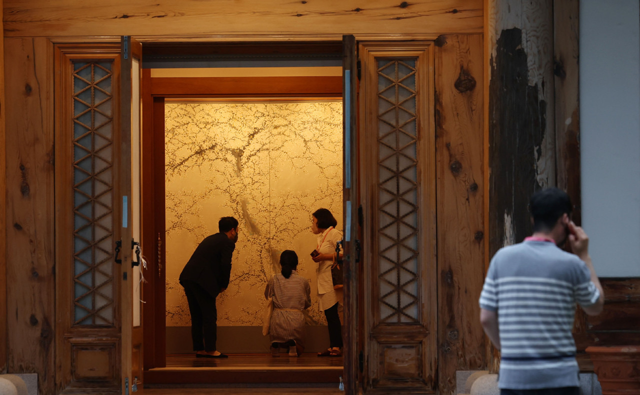 Reporters look at “White Plum Blossom” by Huh Dal-jae on May 25 at Cheong Wa Dae. (Yonhap)