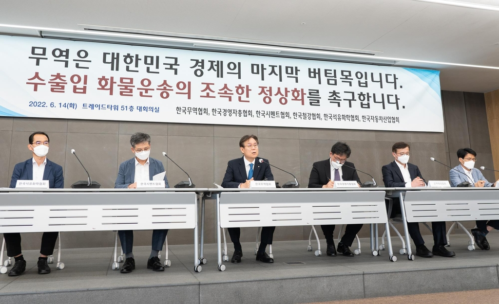 This photo provided by the Korea International Trade Association (KITA) on Tuesday shows KITA Vice Chairman Lee Kwan-sup (3rd from L) and officials from various industry associations holding a press conference in Seoul urging truckers to end their strike leading to massive cargo disruptions in South Korea. (KITA)