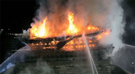 Firefighters try to subdue a fire at Namdaemun, one of the four main gates to Seoul during the Joseon Dynasty, on the night of Feb. 10, 2008. (Yonhap)