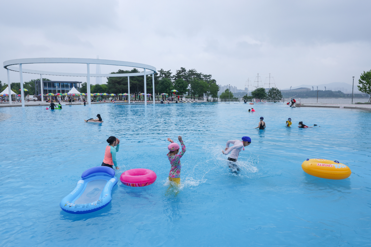 People play in a riverside swimming pool in Seoul last Friday, as four outdoor swimming pools and two wading pools on the banks of the Han River opened the same day following a two-year hiatus due to the COVID-19 pandemic. (Yonhap)