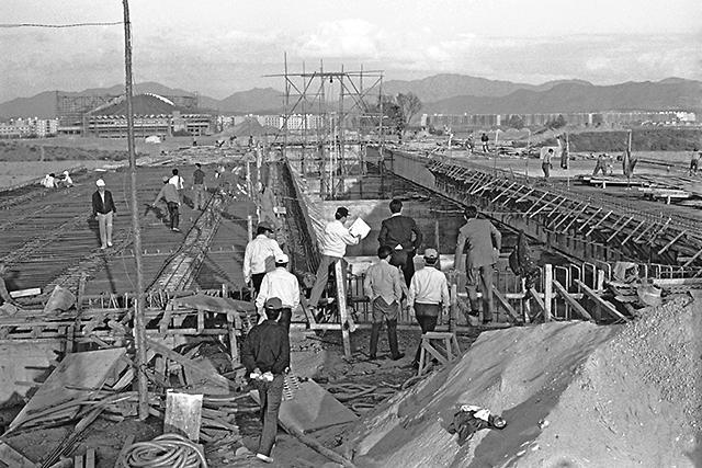People look at the construction site of the Samseonggyo, a 260-meter bridge completed in 1975, connecting Samseong-dong in Gangnam and Jamsil-dong in Songpa-gu. (Gangnam-gu Office)