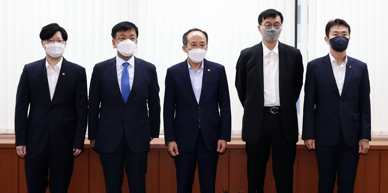 This photo taken on Monday, shows Finance Minister Choo Kyung-ho (C) posing for a photo with the top central banker and the financial regulators ahead of their meeting on economic situations. The participants are Bank of Korea Gov. Rhee Chang-yong (2nd from R); Kim So-young, vice chair of the Financial Services Commission (L); Choi Sang-mok, senior presidential secretary for economic affairs (2nd from L); and Lee Bok-hyun, chief of the Financial Supervisory Service. (Yonhap)