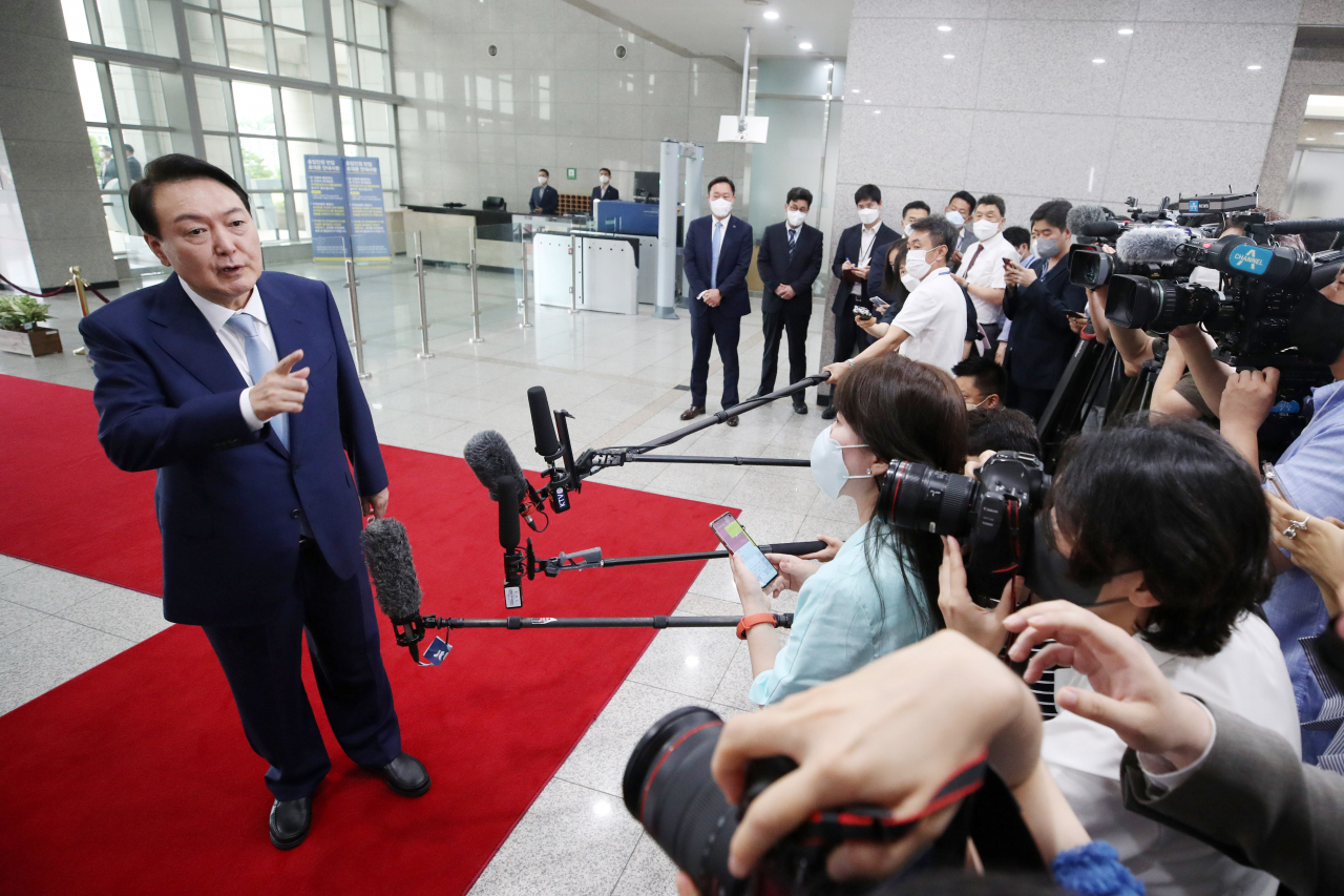 President Yoon Suk-yeol answers reporters' questions as he arrives at the presidential office in Seoul on Tuesday. (Yonhap)
