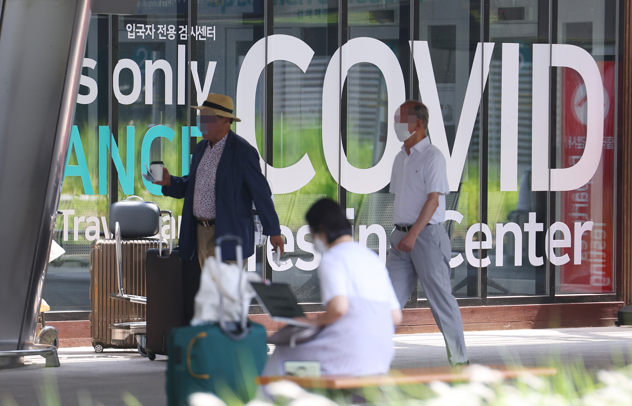People pass a COVID-19 testing station for arrivals at Incheon International Airport, west of Seoul on June 13. (Yonhap)