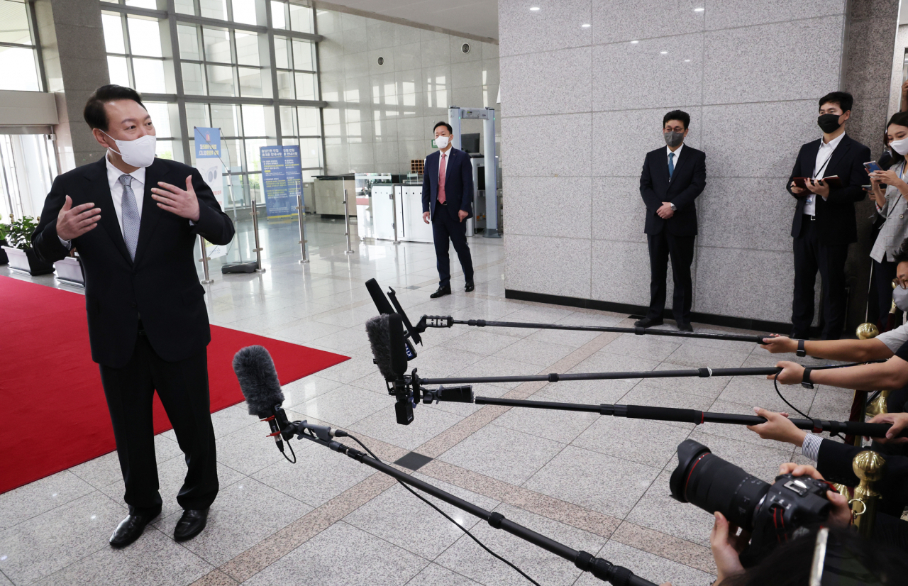 President Yoon Suk-yeol responds to questions from reporters as he arrives for work at the presidential office in Seoul on Tuesday. (Yonhap)