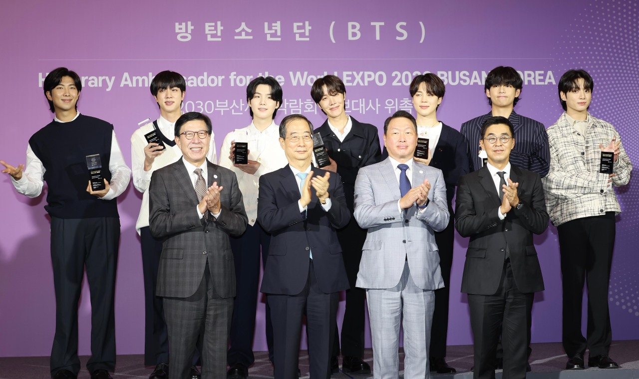 (Back row) Members of BTS, (front row, from left) Busan Mayor Park Heong-joon, South Korean Prime Minister Han Duck-soo, SK Group Chairman Chey Tae-won and Hybe CEO Park Ji-won pose for a picture during BTS members' appointment ceremony as honorary ambassadors for the 2030 Busan World Expo at Hybe's headquarters in Seoul on Tuesday. (Yonhap)