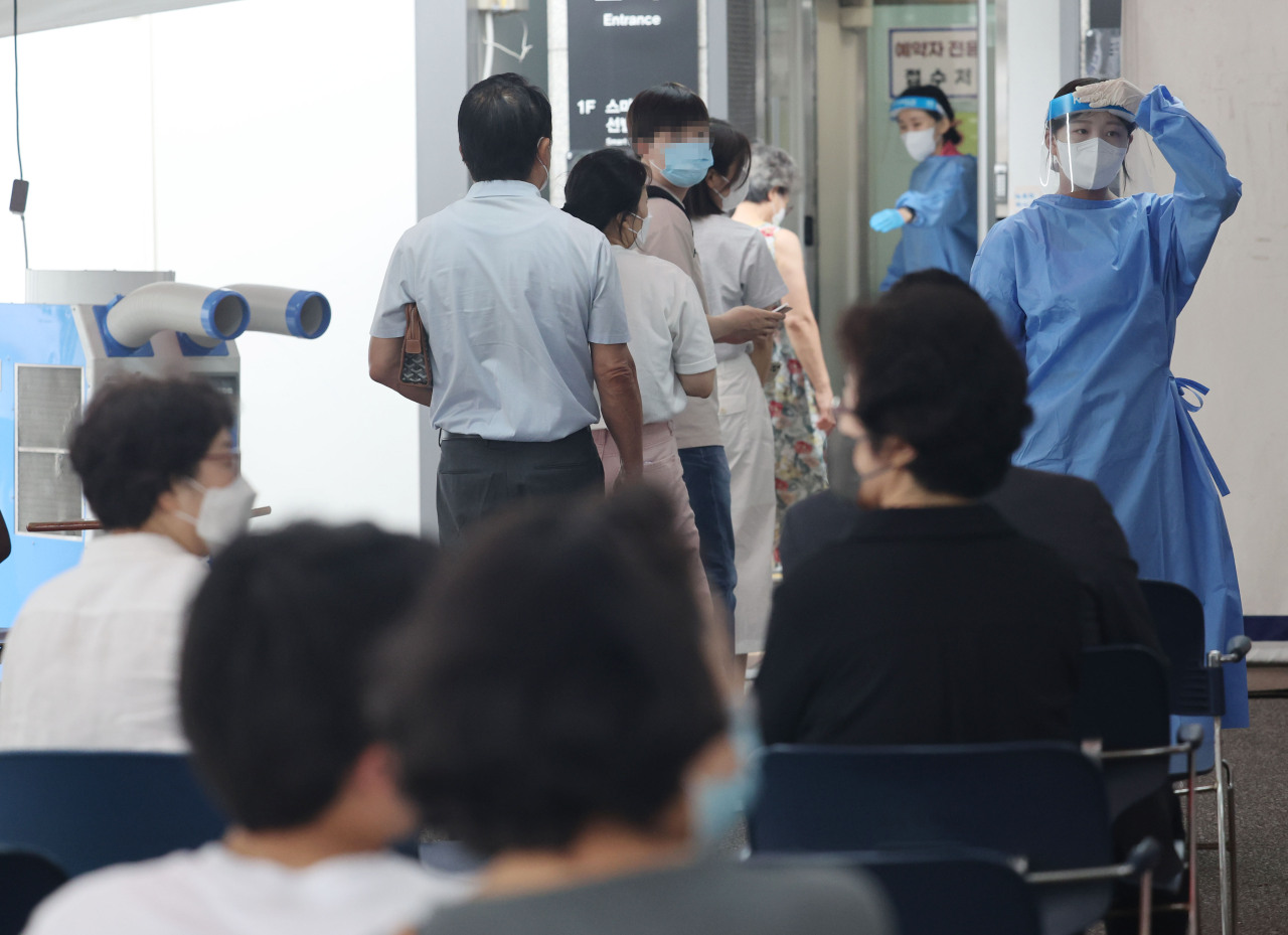 People wait at a local COVID-19 testing station in Gangnam-gu, Seoul, Friday. (Yonhap)