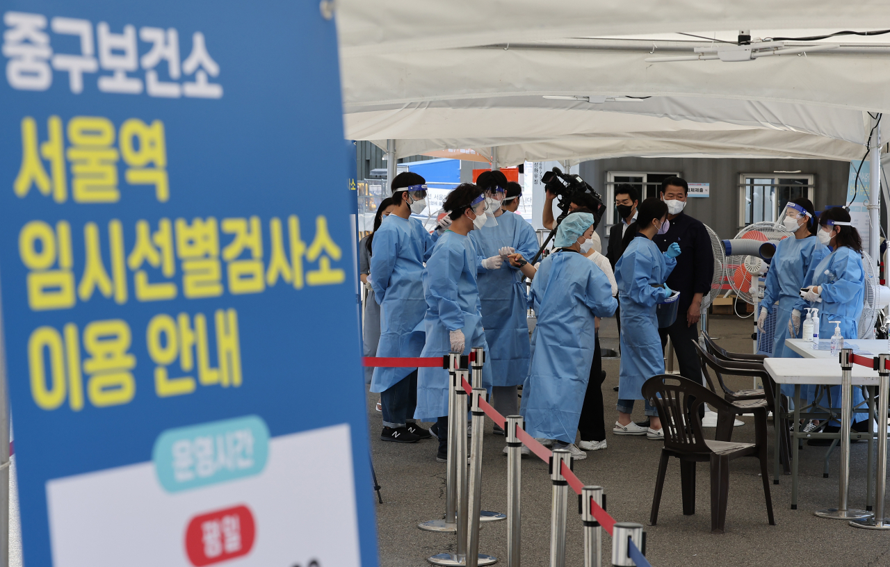 Medical workers get ready to work on Monday, at a COVID-19 testing booth in Seoul that reopened amid the virus resurgence. (Yonhap)