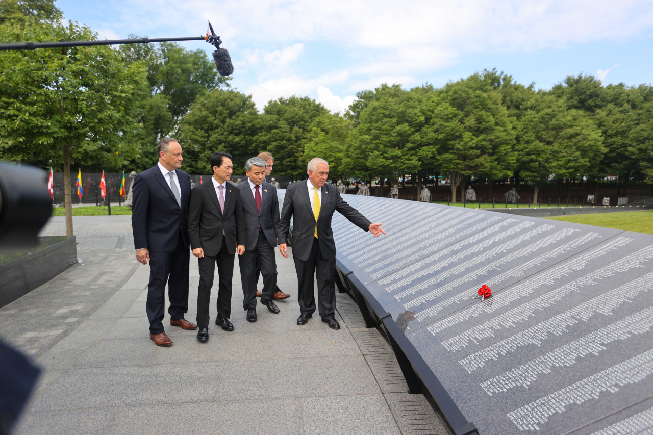 The Korean Defense Minister Lee Jong-sup and Veteran Affairs Minister Park Min-sik listen to the explanation about the Wall of Remembrance on Wednesday from John Tillery, the former head of the US forces in Korea and the chairman of the Korean War Veterans Memorial Foundation. (Yonhap)