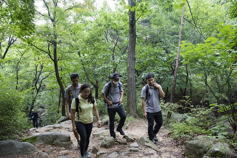 Bambet (left) talks with other foreign hikers while climbing up the mountain. (Seoul Tourism Organization)