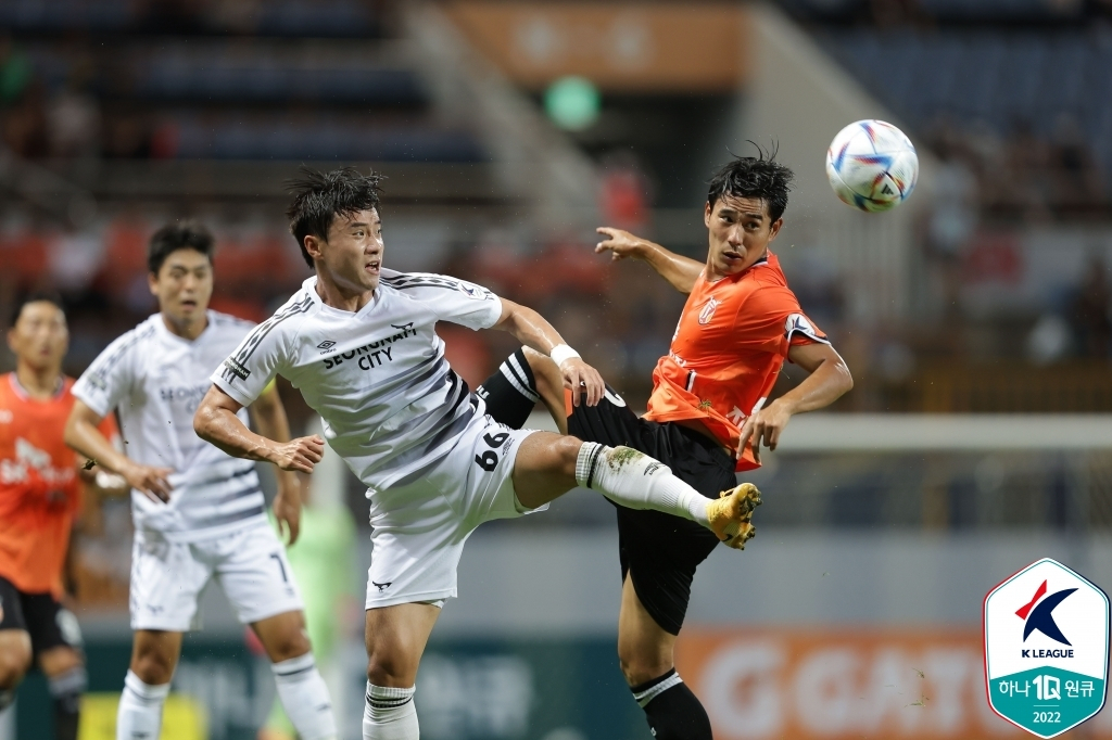 Park Soo-il of Seongnam FC (L) and Jin Seong-uk of Jeju United battle for the ball during their clubs' K League 1 match at Jeju World Cup Stadium in Seogwipo, Jeju Island, on Aug. 2, 2022, in this photo provided by the Korea Professional Football League. (Yonhap)