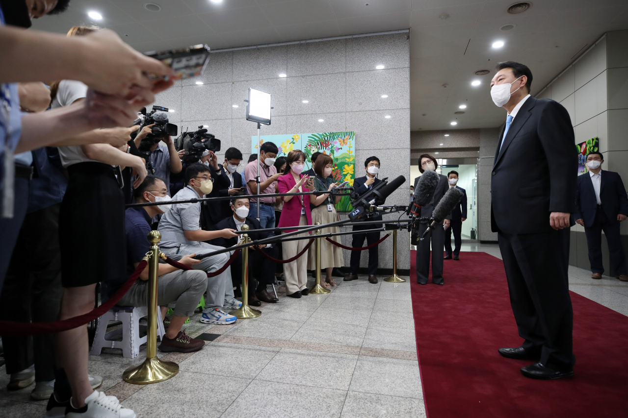 President Yoon Suk-yeol answers reporters' questions while arriving for work at the presidential office in Seoul on Monday, after a weeklong summer vacation. (Yonhap)