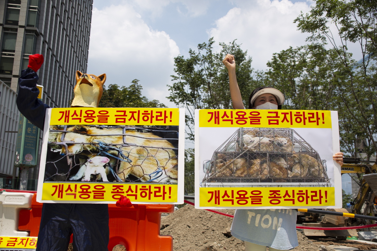 Members of an animal activist group shout slogans and hold banners reading 'Ban Dog Eating' during a campaign against eating dog meat in Seoul on July 22. (EPA-Yonhap)