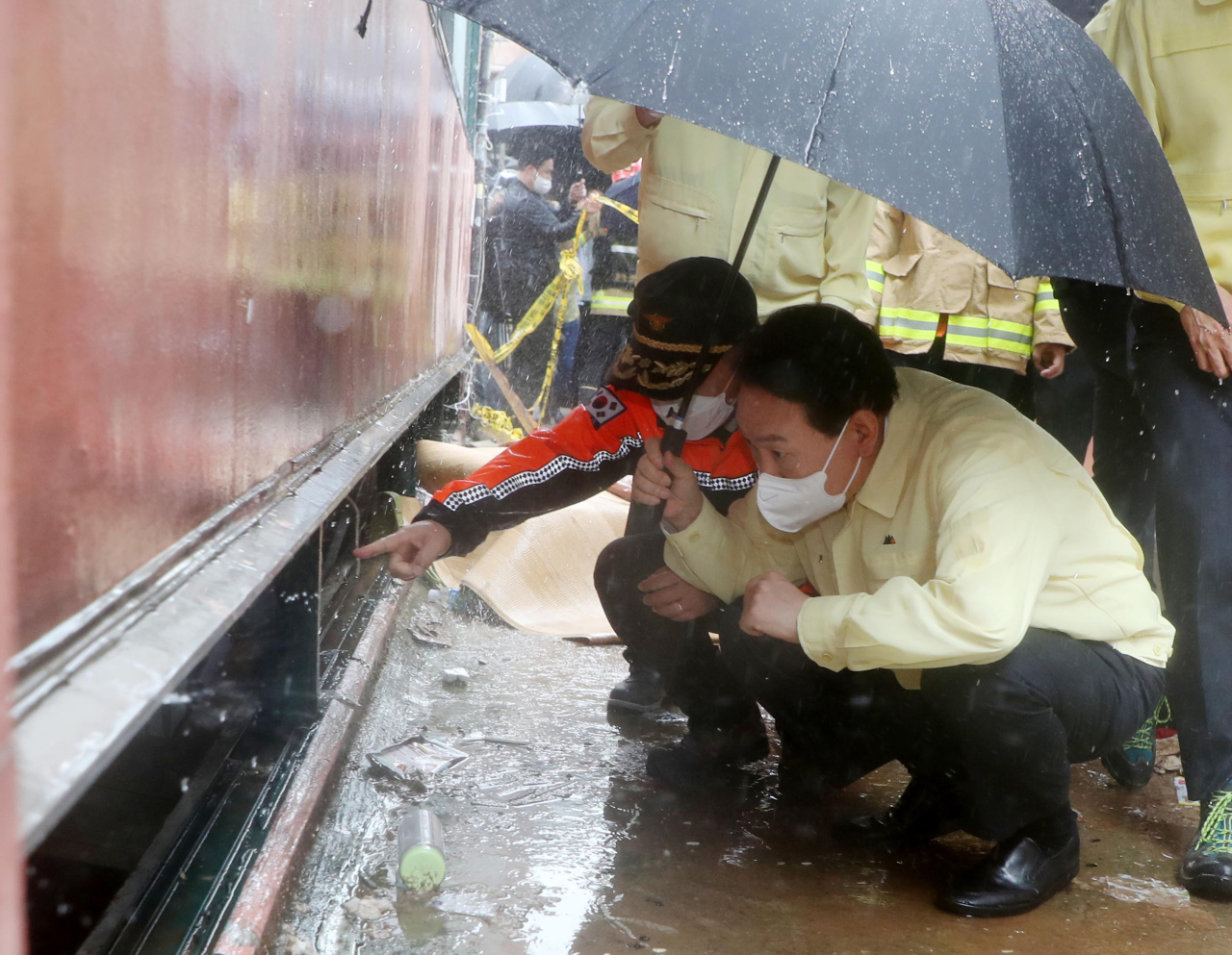 President Yoon Suk-yeol visits a basement home shattered by downpours in Gwanak-gu, southwestern Seoul, on Tuesday. Three people living in the basement were killed in flooding the night before. (Yonhap)