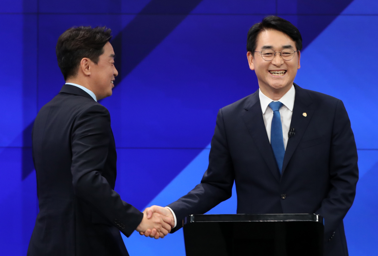 Rep. Kang Hoon-sik (L) and Rep. Park Yong-jin of the main opposition Democratic Party shake hands in a chairmanship candidate debate hosted by local television outlet G1 in Chuncheon, Gangwon Province, in this last Tuesday file photo. (Yonhap)