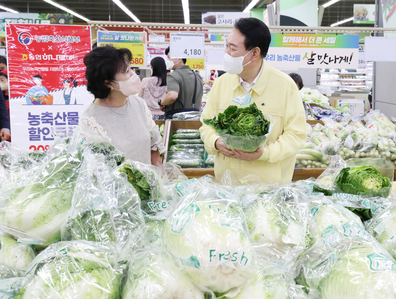 President Yoon Suk-yeol (right) talks with a citizen during his visit to a large discount chain in Seoul on Thursday to map out policies to tame inflation. (Yonhap)