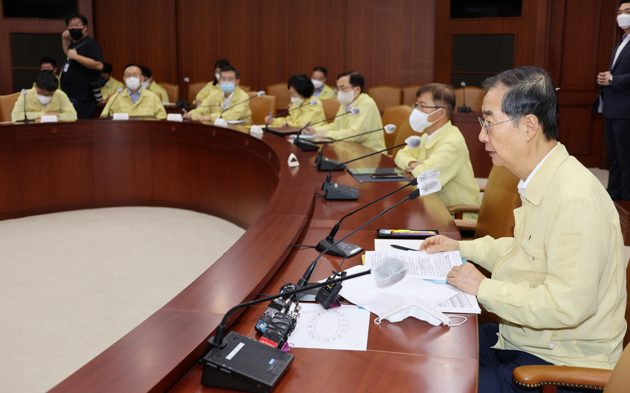 Prime Minister Han Duck-soo (2nd from R) presides over a meeting at the government complex in Seoul on Friday, to check countermeasures against torrential rain. (Yonhap)