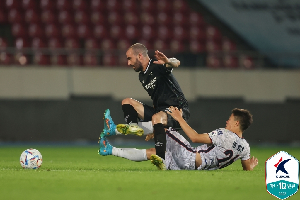 Milos Raickovic of Seongnam FC (L) is tackled by Kwon Chang-hoon of Gimcheon Sangmu FC during the clubs' K League 1 match at Tancheon Stadium in Seongnam, some 20 kilometers south of Seoul, last Friday, in this photo provided by the Korea Professional Football League. (Korea Professional Football League)