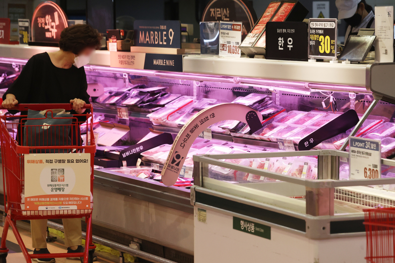 A consumer looks at livestock products at a large discount chain in Seoul on Thursday. (Yonhap)