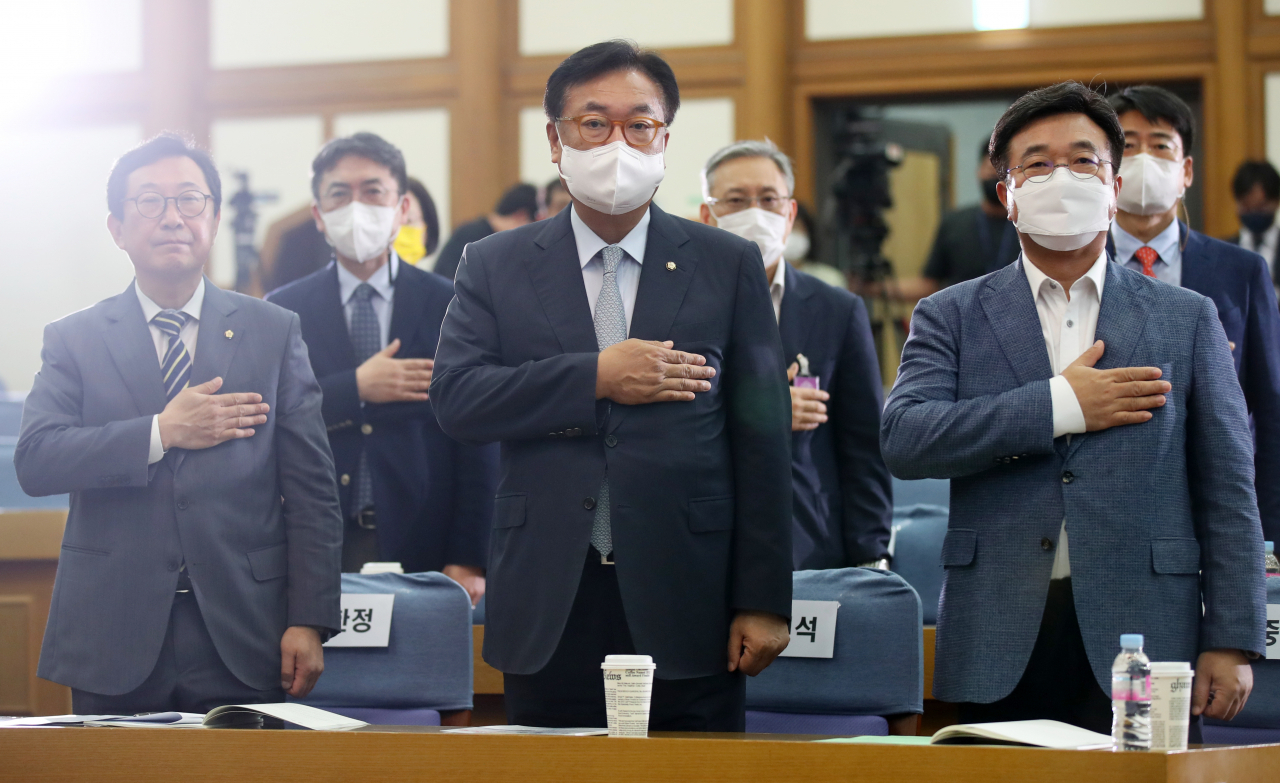 Rep. Chung Jin-suk (C), vice speaker of the National Assembly; Rep. Kim Han-jung of the main opposition Democratic Party (DP) (L); and DP Rep. Yun Ho-jung pledge allegiance to the flag last Wednesday. (Yonhap)